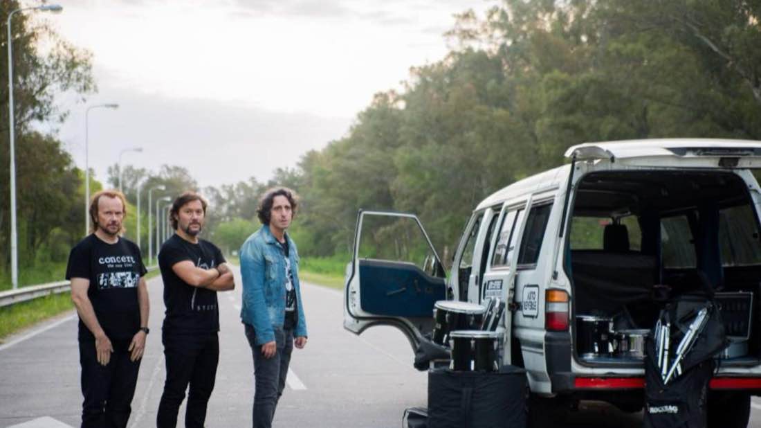 Band at a road stop by the tour van
